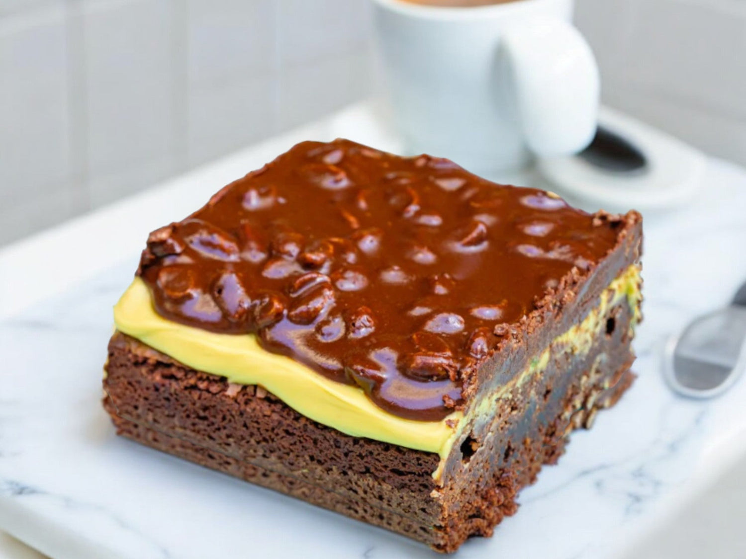 pistachio brownie topped with pistachio cream and chocolate ganache