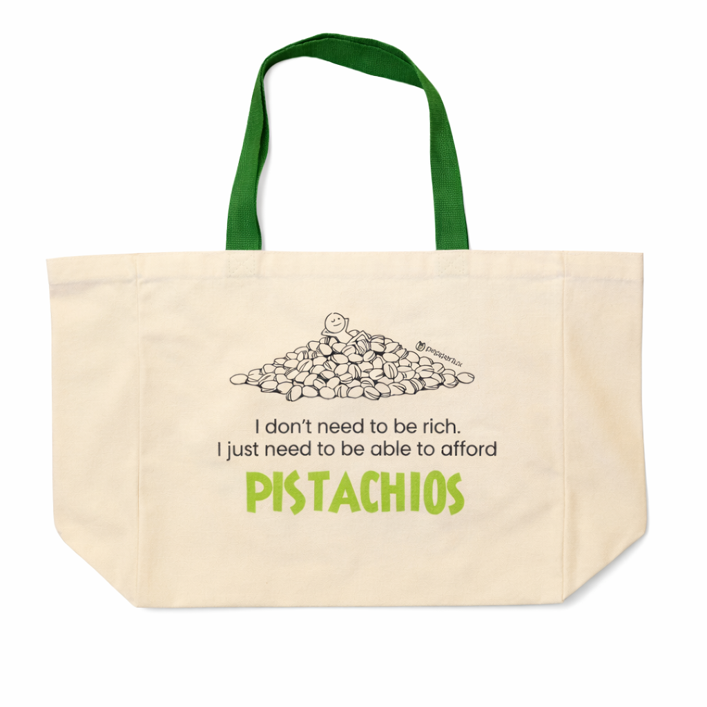 Beige tote bag with green handles featuring a graphic of pistachios and humorous text on a white background.